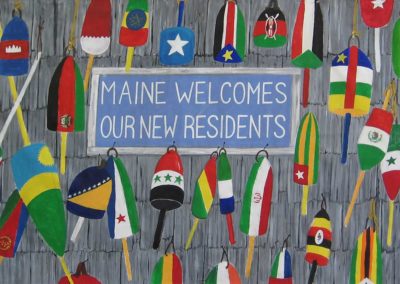 lobster bouys painted with the colors of the flags of the countries where Maine immigrants have come. Messge Maine Welcomes our New Residents.