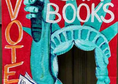 Lady liberty reading a book and holding her flame, free societies don't ban books - vote