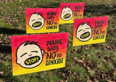 4 yard signs all with stop! in a childs mouth and Maine says, No to genocide
