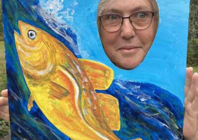 Picture of a fish jumping a fish ladder with a hole for persons face to show & I VOTE